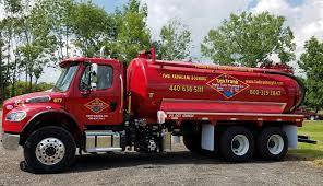 Red septic tank truck with Tim Frank Septic company logo on the side of it.