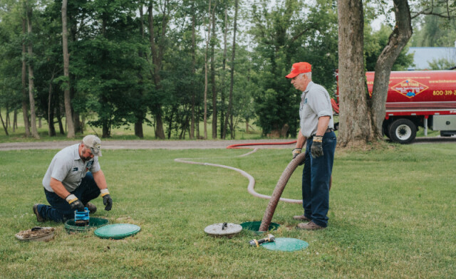 Two certified septic system inspectors from Tim Frank Septic performing an inspection and routine pumping of a septic system
